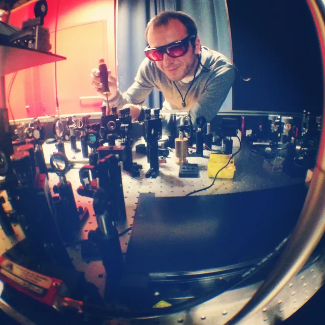 Alex adjusting an optical setup in a laboratory