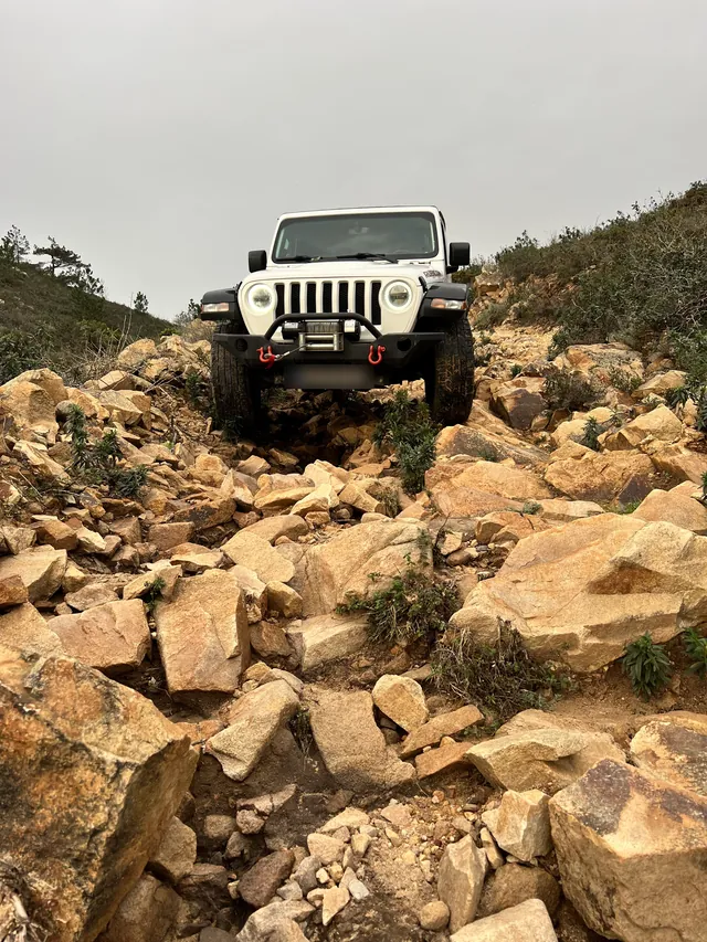 Off-road vehicle climbing a rocky trail