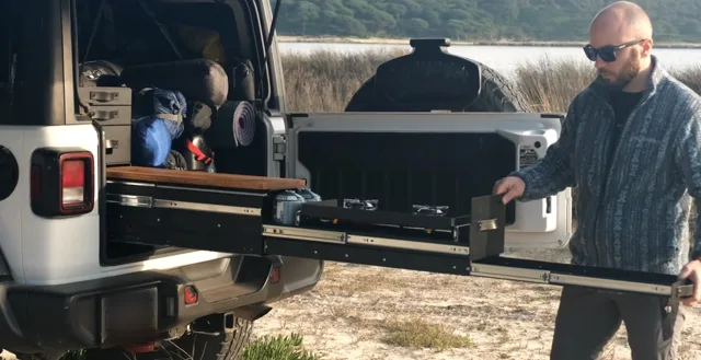 Alex sliding the Emmer kitchen out of the trunk by the water