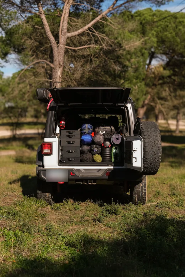 Open trunk with the Emmer kitchen on one side and camping gear packed beside it